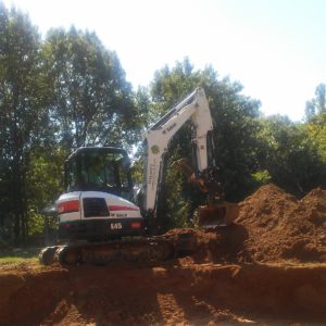 A white and black excavator is on the dirt